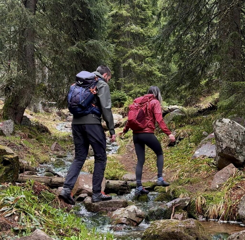 Couple walking over the creek at Stara Planina